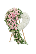 Heart-shaped arrangement with pink flowers and greenery on a white background